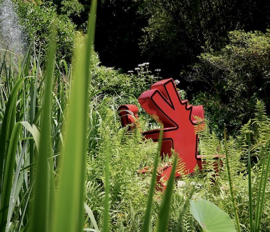 Una scultura di Keith Haring spunta dal verde del giardino botanico Heller a Gardone Riviera